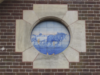 902880 Afbeelding van een rond Delfts blauw tegelplateau met een afbeelding van trekpaard bij het ploegen, in een ...